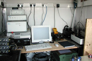 The laser, and optical bench (right hand side of image), along with heater controller, computer, digital signal processor, photodetecor module, and rotator controller (stack at left of image). Deployment in the Tow-A-Van mobile lab during the NAMBLEX project, August 2002.